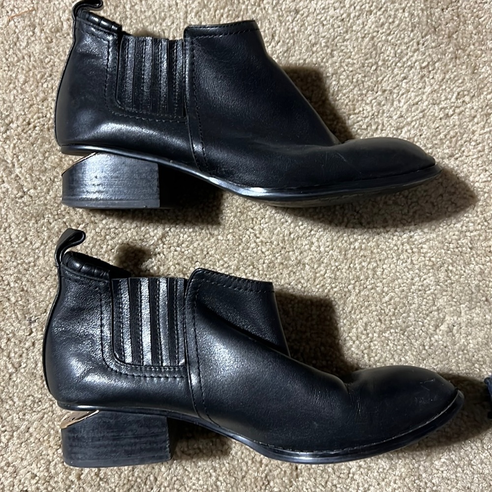 Rose gold notched heel black leather booties